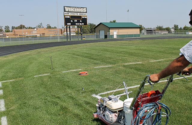 Painting of the sidelines and other field markings prepares the field for the first V-S home game.