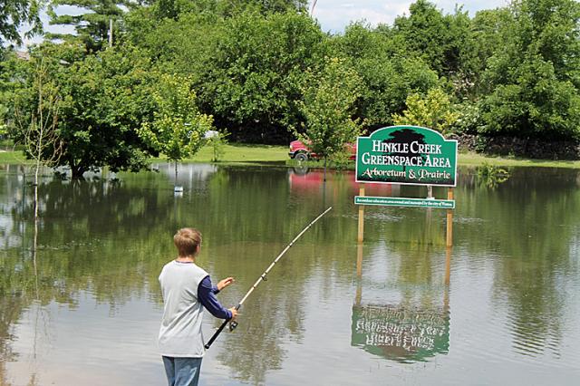 Cory Kite tries his luck in the flooded green space near Hinkle Creek on Thursday.