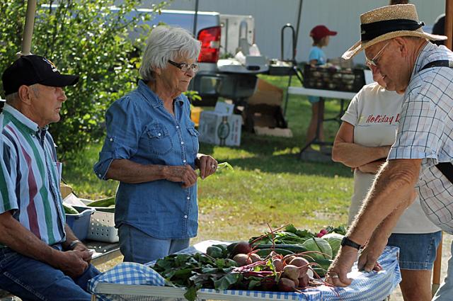 The Womochils and Struves discuss sweet corn and other items during the Farmers Market.