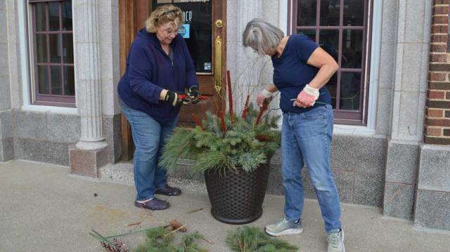 Members of the Cottage Garden Society, Brenda Hackbarth and Cheryl Knaack, help to decorate the town