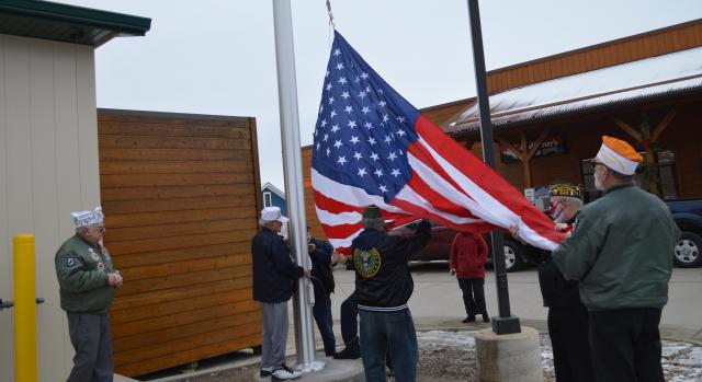 Area AMVETS install a new flag at John's Qwik Stop