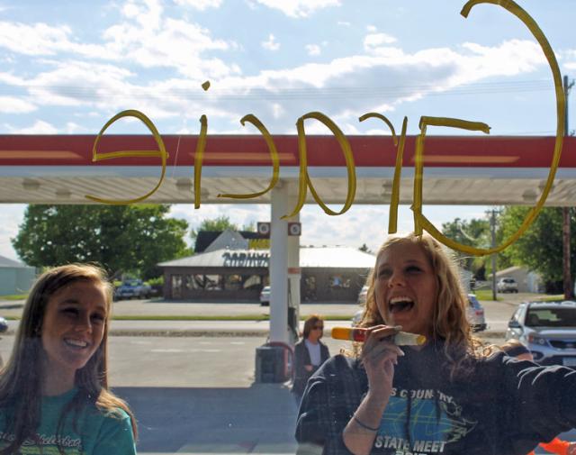 State Track supper tradition: Taylor Spies watches as Grace Horst decorates a window at Ehlinger's.