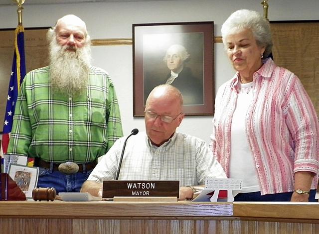 Garden Club members Jim Huber and Fran Stueck watch Mayor Watson sign the Garden Week Proclamation.