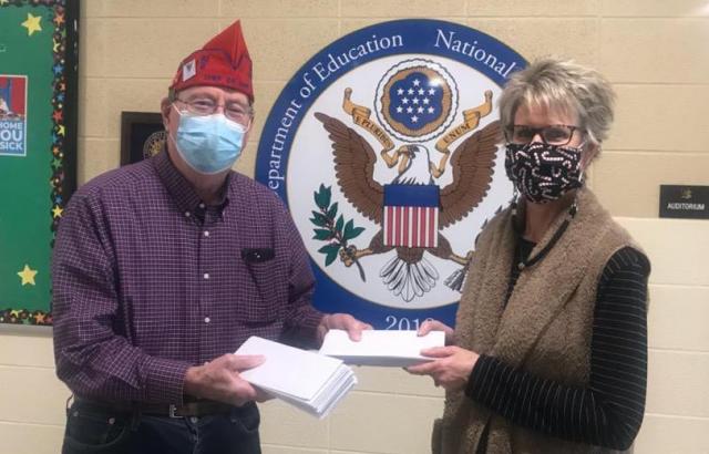Alan Woodhouse presents Molly Noren with a $1,000 donation of gift cards for The Backpack Program