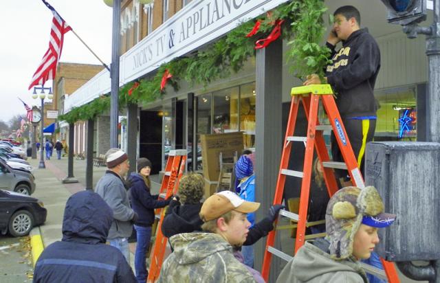 A large group of VSHS students and volunteers decorated downtown with greenery and red bows.