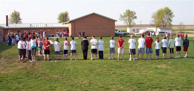 CLS students line the perimeter of the new gym building with the facade of old gym in background.