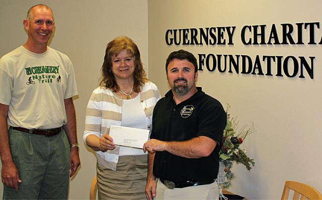 Matt Purdy and Randy Scheel accept the OCNT donation from The Guernsey Foundation's Soo Greiman.