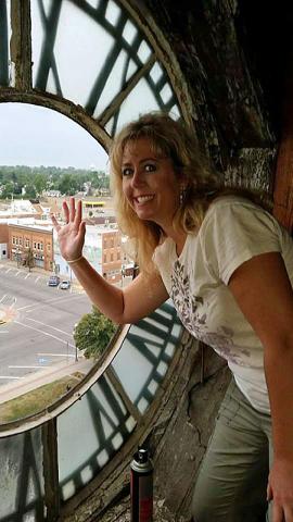 Something missing: Courthouse employee Hayley Rippel waves from the gap left by the clock removal.
