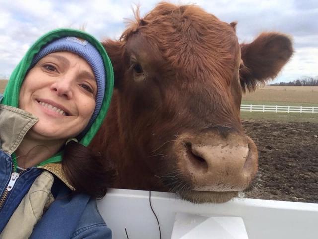 Heidi Lillibridge poses with one of the cows on the farm,