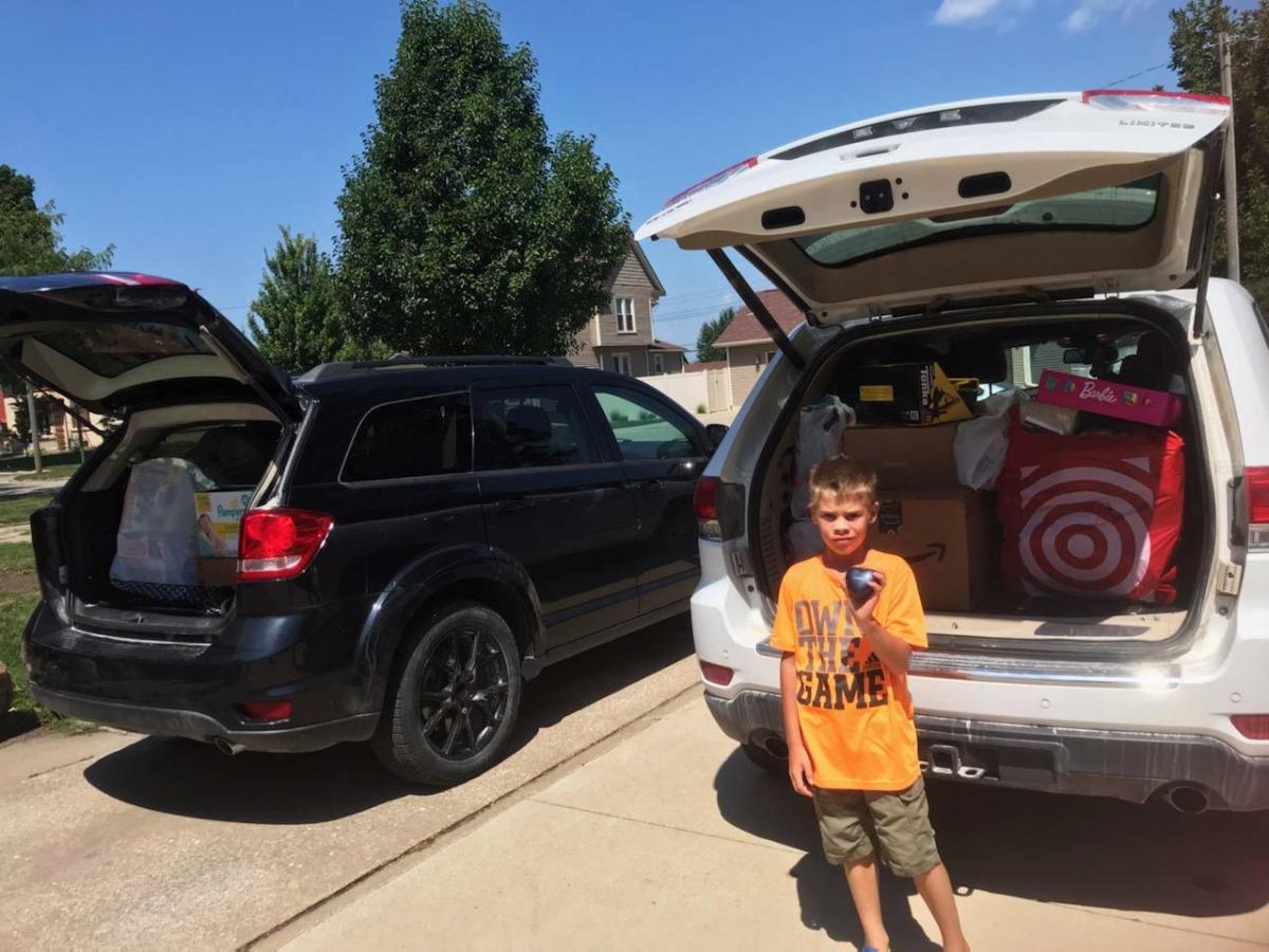 Hunter Lindeman holds a heart with the name of his brother Easton on it in front of the gifts that went to the Children's Hospital in honor of Easton