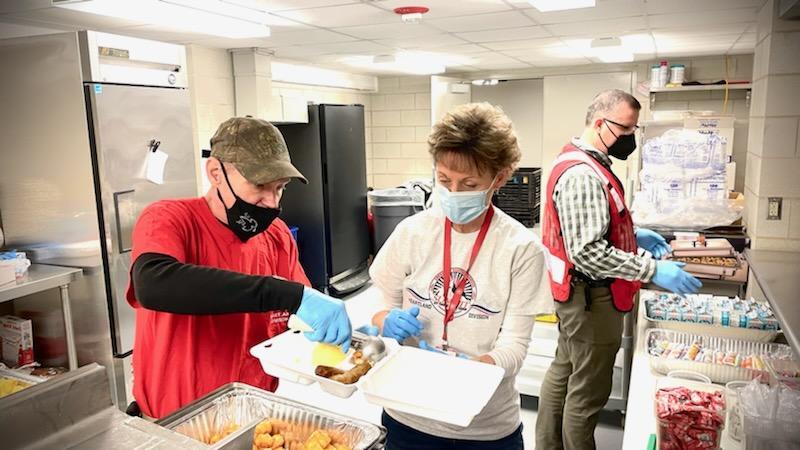Scott White and Julie Hansen of Vinton and Brian Reeves of Shellsburg, served meals to displaced residents of the Geneva Towers