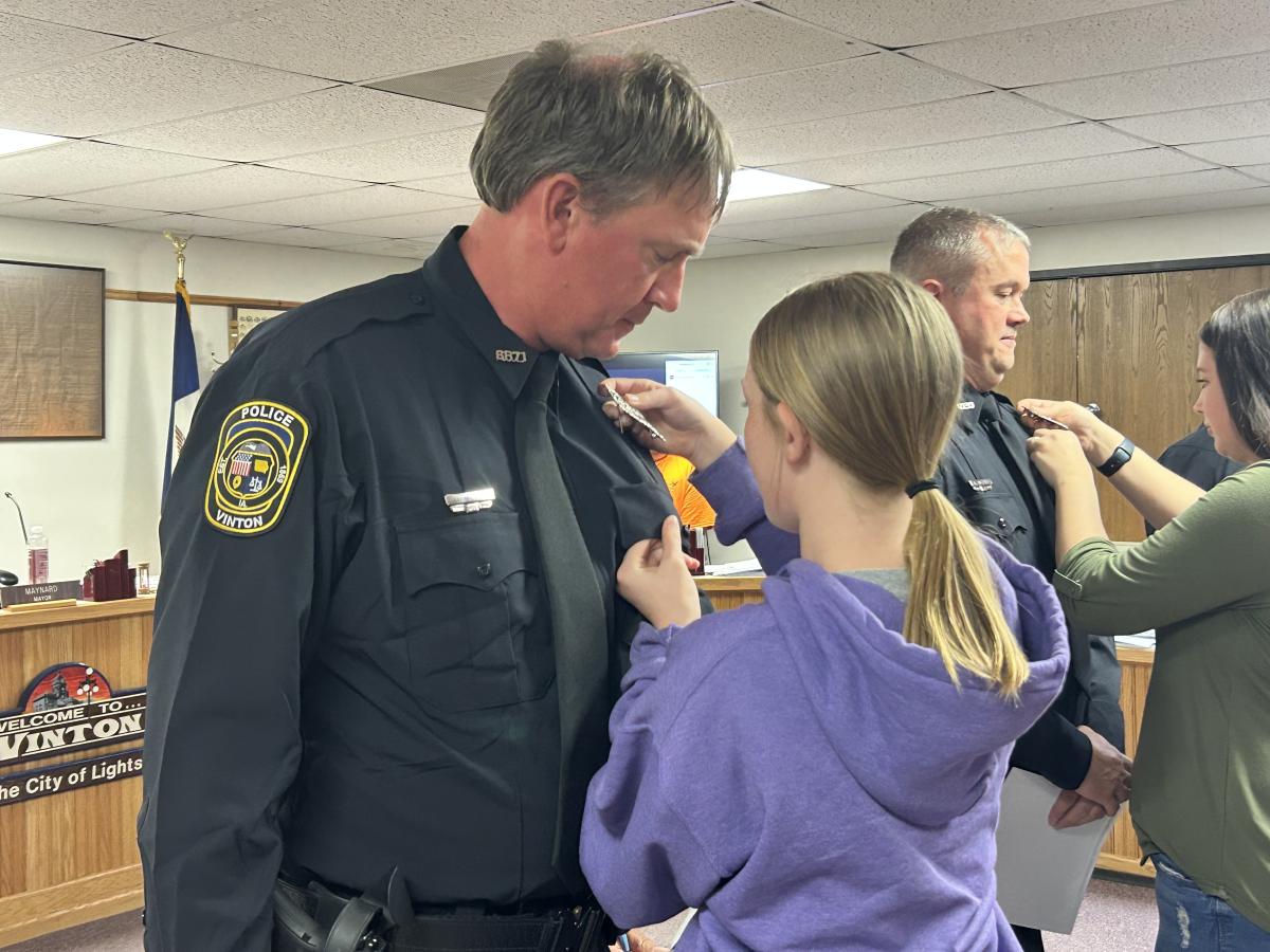 Joshua Meyer having his badge pinned on by his daughter