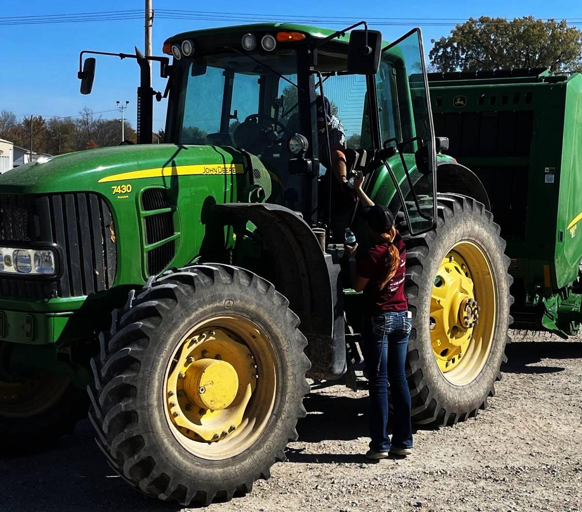 Izzie Birker handing a meal to a farmer as he pulls into the Tama-Benton Co-op.
