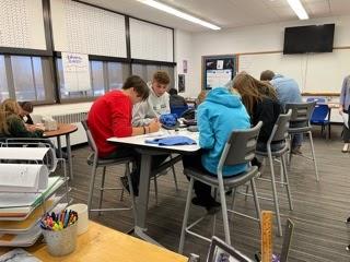 Spencer Williams, Keyten Grimm, Abby Osborn, and Dakota Deklotz, working together in a workshop.