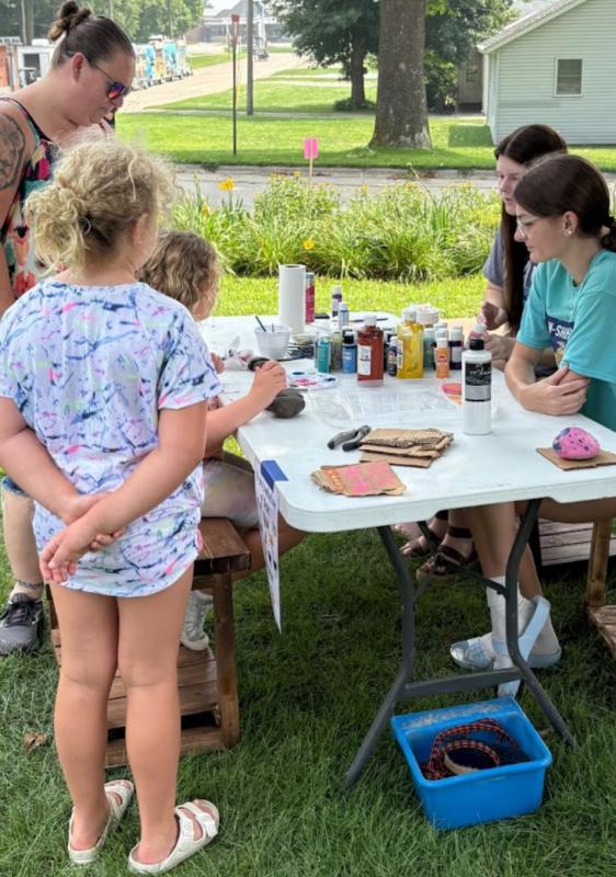 Kassidi Brunssen and Zyla Mullinex helping kids paint rocks.. Click to read article