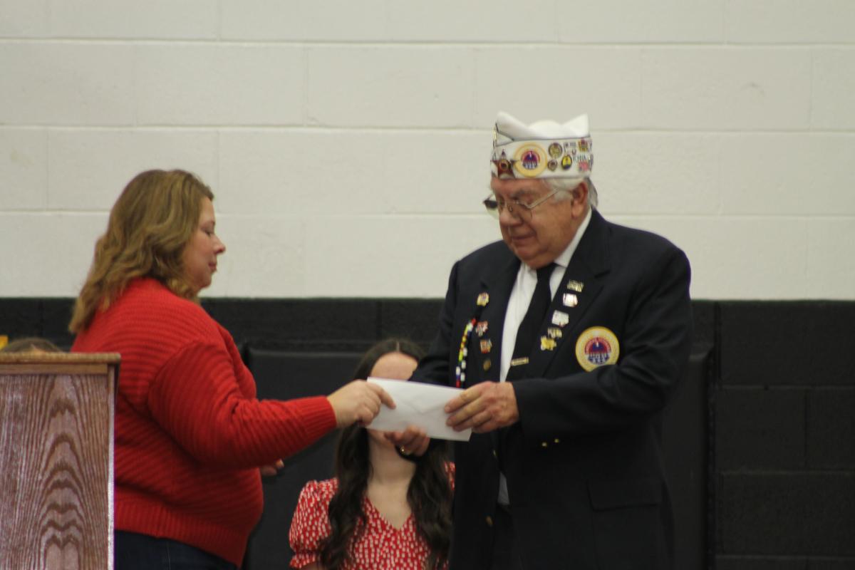 Dennis Miller is presented a check by Kelly Steffen for the AMVETS