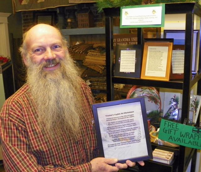 Jim Huber holds some of his framed works of poetry; they are offered to customers at Clingman's.