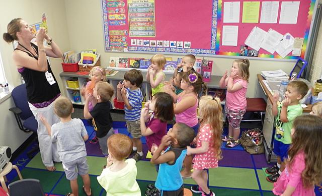 Tiny Vikes preschool classes began Wednesday; her Nicole Lutz leads the children in a song.