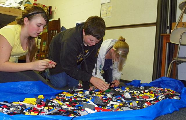 Kayla Schneider, Logan Murray and Caitlyn Martin look for just the right Legos for the robot.