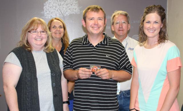 Jason Cantrell, (center) receives the first $120 gift card from the Vinton Lions Club.