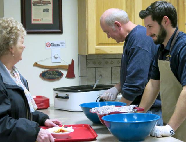 Lion Mike Barron checks the chili while first-year member Will Ketchen serves Cindy Elwick.