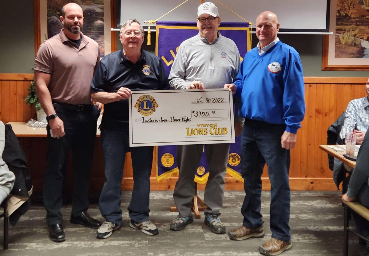Vinton Loins Club member Scott Barron, Dr. Alan Woodhouse, Roger Uthoff, present a check to Dick Bell, of Eastern Iowa Honor Flights.