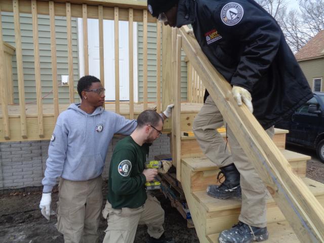 Darius, Max and Montell work together to put the railings on a new porch