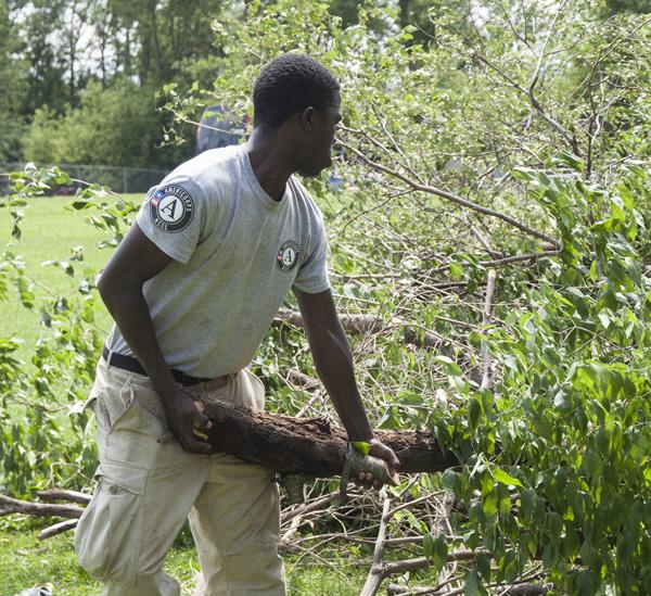 Ali Noor, Maple 3, moving debris cleared from the mountain biking trail to the wood chipper.