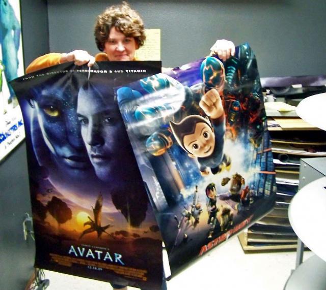 Palace Manager Marcy Horst holds two of the movie posters available for those who donate $100.