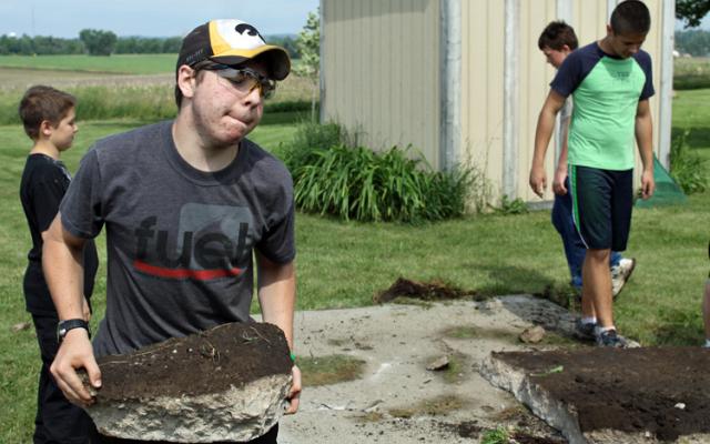 Matt Lash helps carry pieces of concrete to an end-loader.