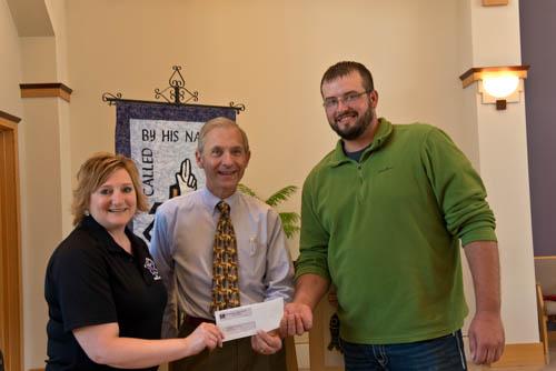 George Bauer presents the Bethlehem $102 donation to Tina Eden and Zach Parmater.