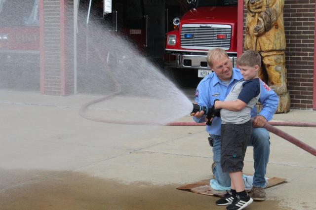 Children enjoying a chance to spray the fire hose at the station