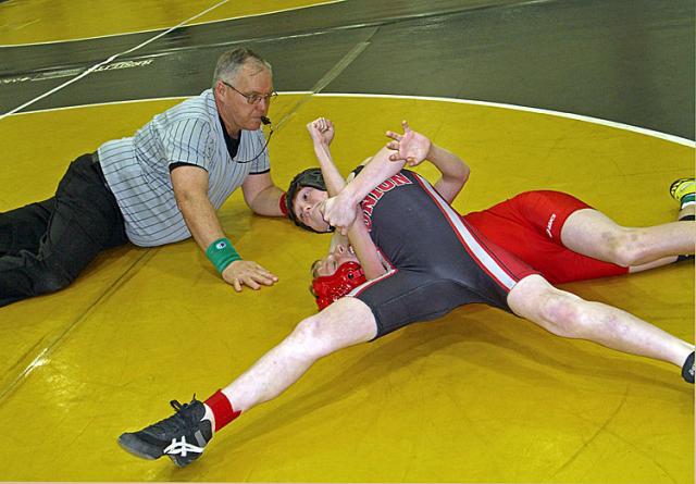 Ref Dick McKenna watches a wrestler go for a pin.