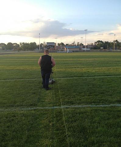VS Alumni Football: Viking Logan Merchant mows the lines of the field.