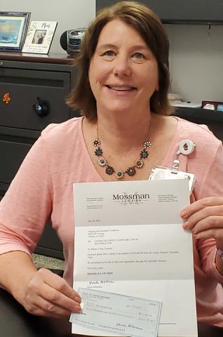 Michele Schoonover holds check & letter to VGHHCF from the Louise Gilchrist Charitable Trust