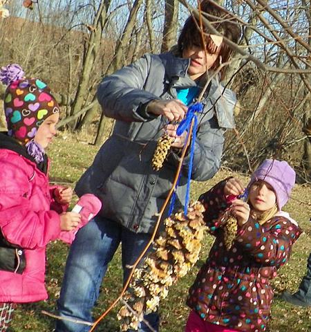 Mrs. Mathis helps some girls with their pine cone bird feeders.