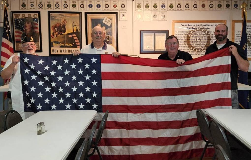 Craig Streeter, Legion Commander and Roger Uthoff accepting the flags from Scott Barron, Lions Club President and Alan Woodhouse, Lions Treasurer.