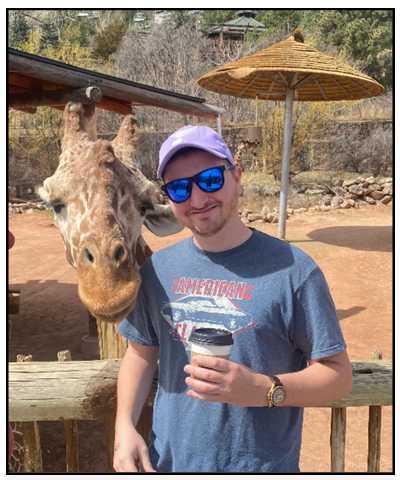 Ranger Wille with a giraffe at Cheyenne Mountain Zoo. Click to read article
