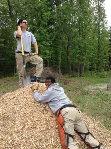Gabe Dzurny and Cameron Chiles have fun with the mulch pile that was used to make a trail.