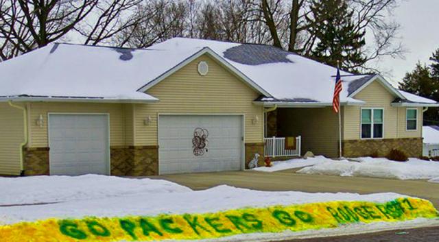 A Green Bay Packer fan painted green and yellow in the snow near Dennis Bramow's house.