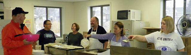Duane Randall talks to the Kiwanis kitchen crew as they make pancakes.