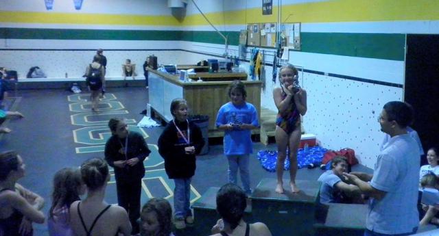 VAC Assistant Coach Mike Dominick presents a first-place trophy to Clarissa Carolan.