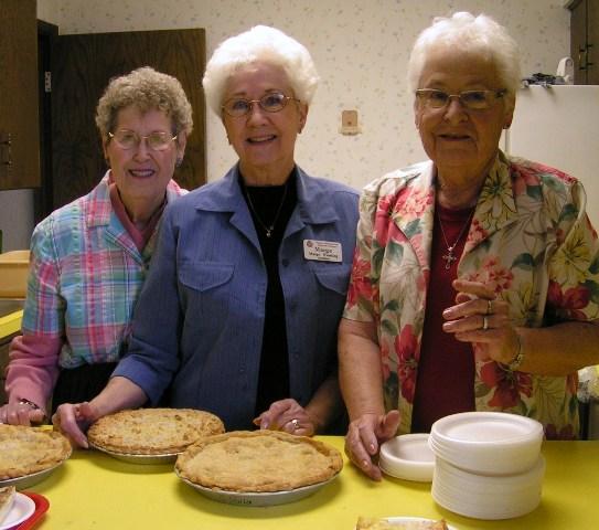 Evelyn Roths, Marge Wessling and Dwyn Garwood cut homemade pies to serve during the luncheon