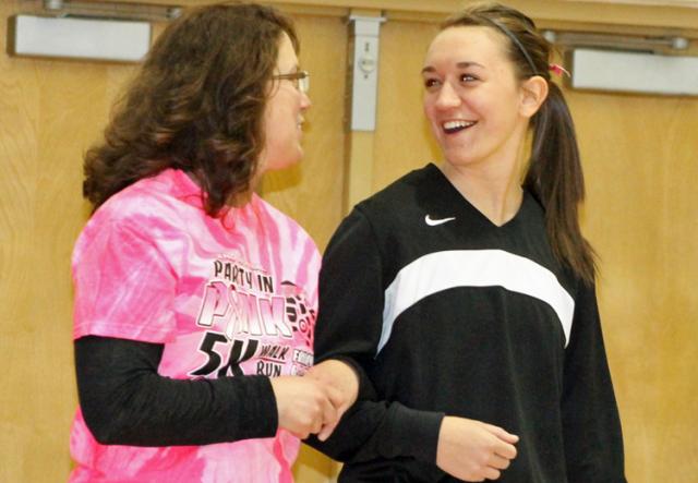 Vikette Brea Burroughs escorts survivor Angie Tharp to the court on Pink Night.