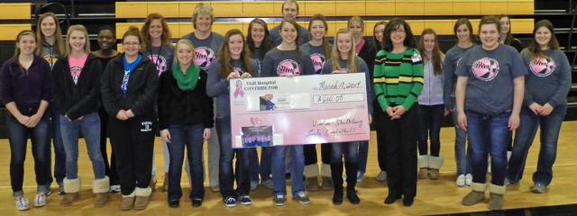 Vikette basketball players presented the Pink Night check to Monica Stark on Monday.