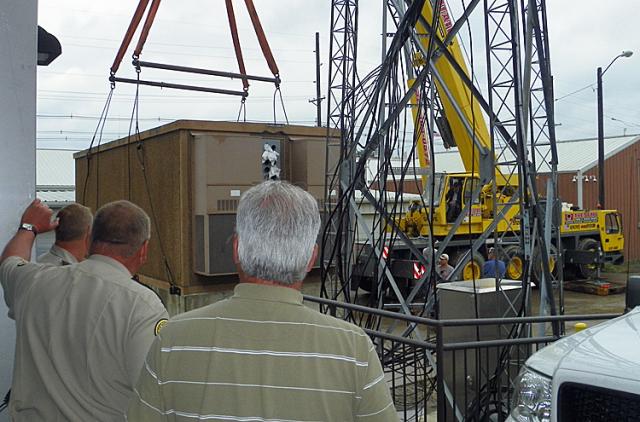 Deputies watch the removal of the temporary 911 communications building.