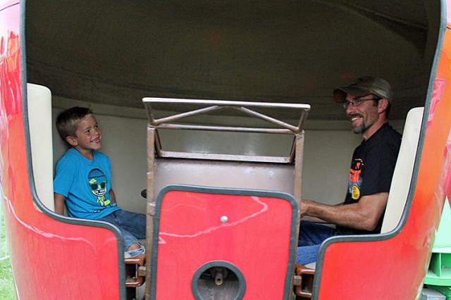 A father and son enjoy the spinning apple ride.