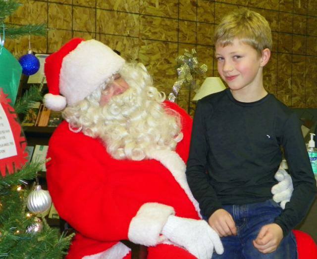 Cyrus Elwick speaks to Santa at Farmers Bank during the open house event Friday.