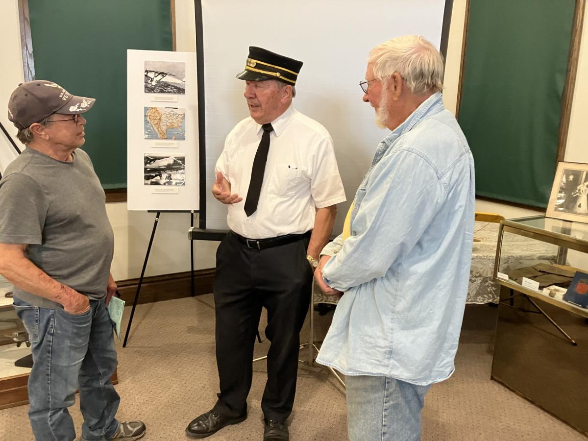 Phil Borleske, center, talks more train with railroad enthusiasts after his presentation “All Aboard: a Snapshot of Iowa Railroads, Past and Present” at the Center Point Historical Society Depot Museum, June 25.