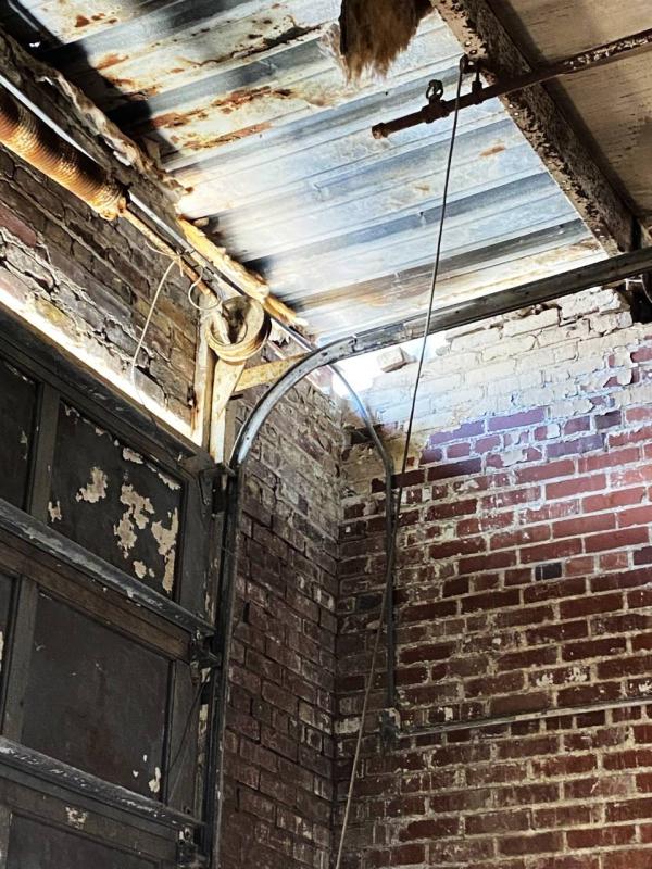 Photos show the failing masonry on the west wall weakening the steel supports which hold the roof